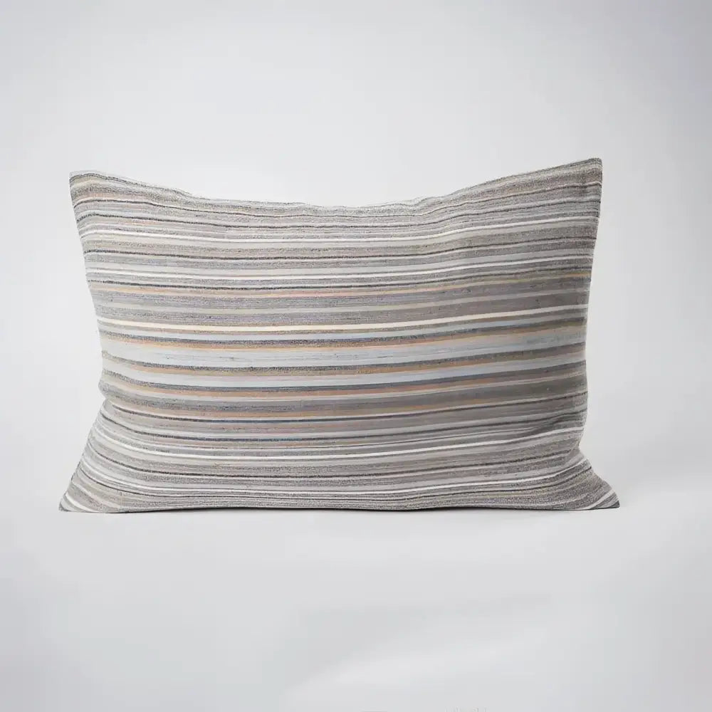Front side of striped pillow in blues, greens, and natural colors.