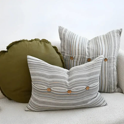 Back side of two striped pillow in blues, greens, and natural colors.