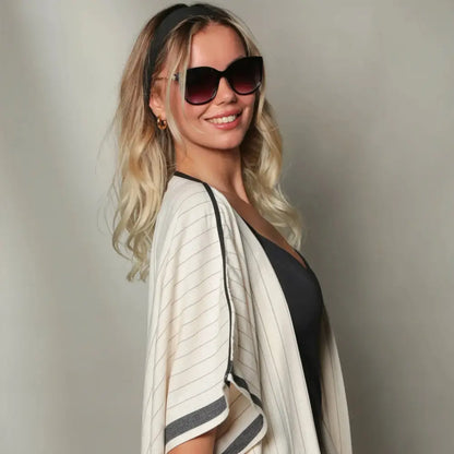 A kimono style cover up in natural color with soft black stripes.