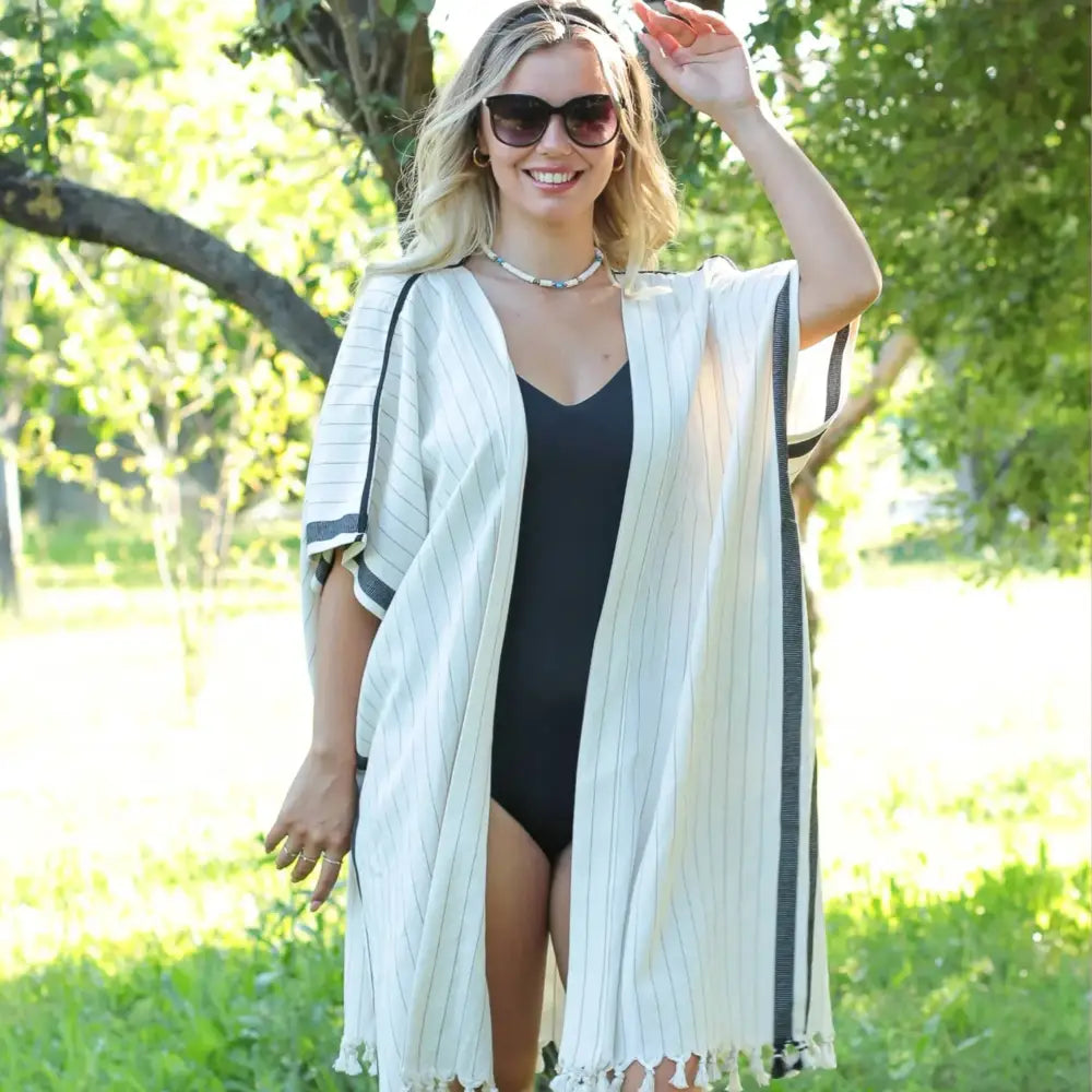 A kimono style cover up in natural color with soft black stripes.