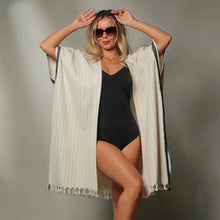 A kimono style cover up in natural color with soft black stripes.