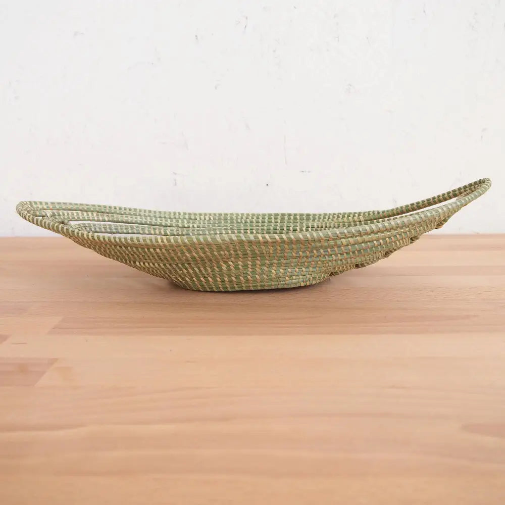 Light green woven boat-shaped basket made from sweetgrass and swamp grass for African bread
