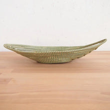Light green woven sweetgrass African bread basket shaped like a boat for serving bread
