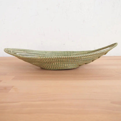 Light green woven boat-shaped basket made from sweetgrass and swamp grass for African bread