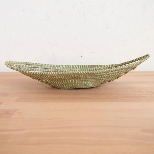 Light green woven boat-shaped basket made from sweetgrass and swamp grass for African bread
