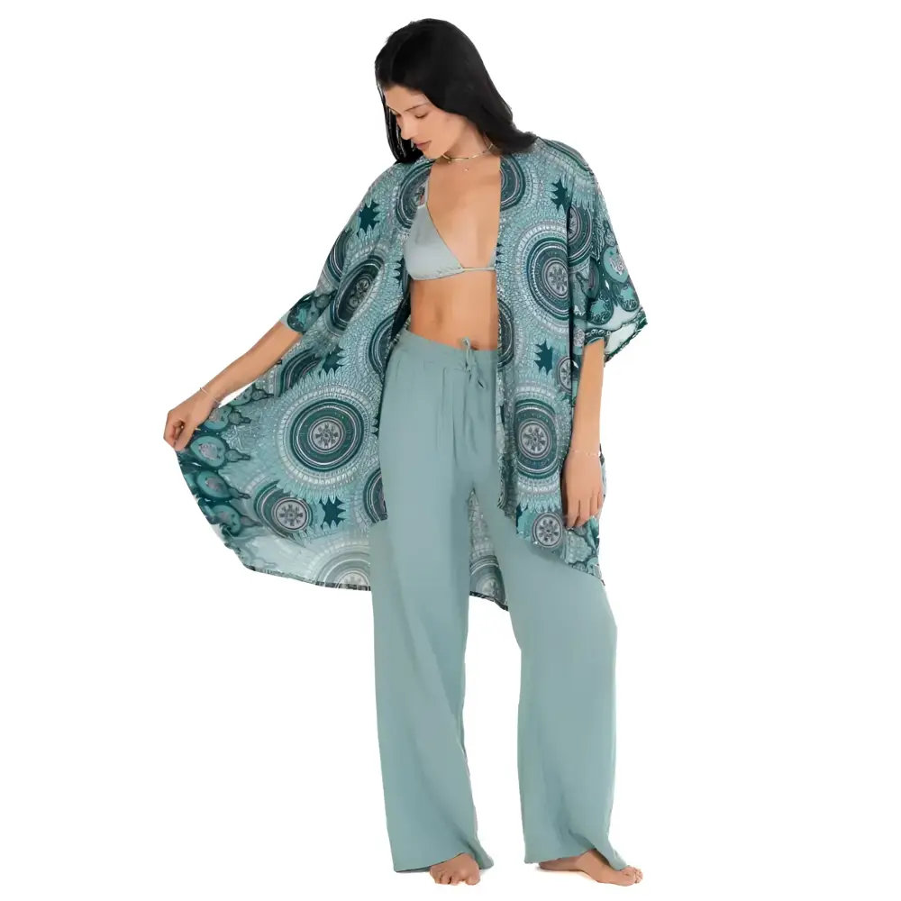 A flowing teal mandala kimono cover-up with circular patterns worn over matching wide-leg pants
