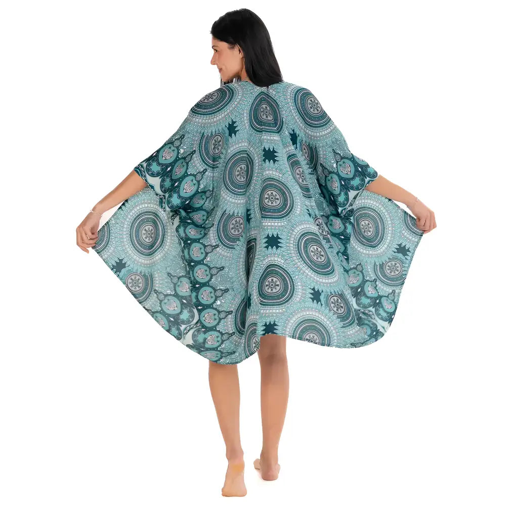 A flowing teal mandala kimono cover-up with white patterns and intricate circular mandala designs