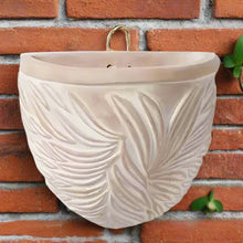 Off-white terra cotta wall planter with embossed leaf pattern and golden hanger