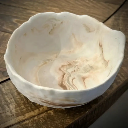 White ceramic bowl with wavy edges and brown marbled interior, perfect for textured raw edge style
