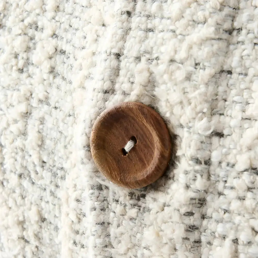 Off white and gray textured hand woven 20 inch x 20 inch pillow cover with three brown coconut buttons on one side 