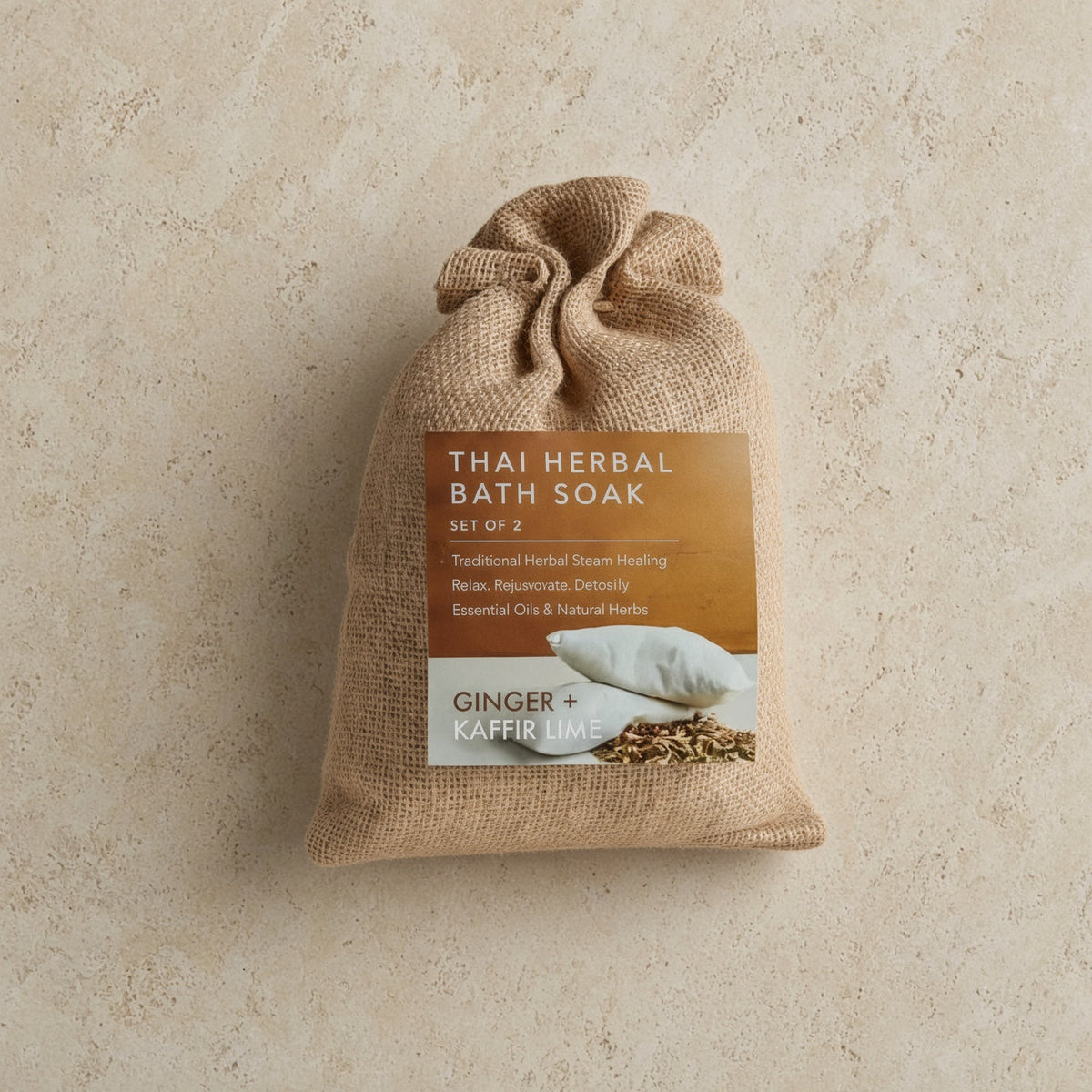 A beige burlap sack with a thai herbal bath soak handmade set featuring ginger and kaffir lime for soft skin