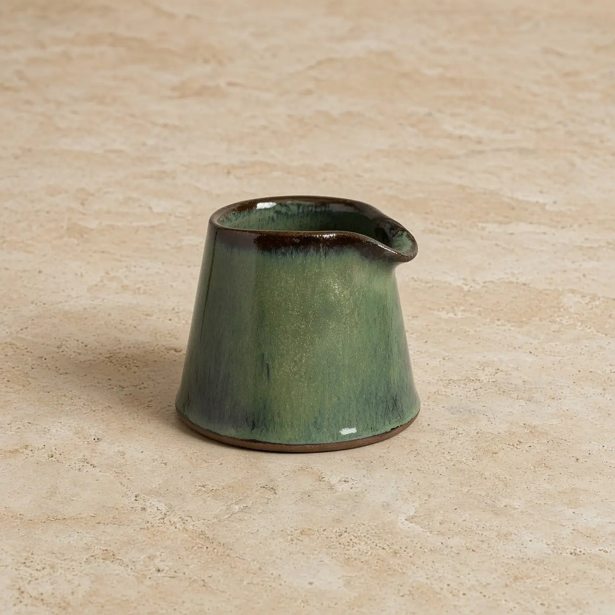 Tiny handmade ceramic pitcher with glossy green glaze and dark brown rim perfect as a ceramic condiment pitcher
