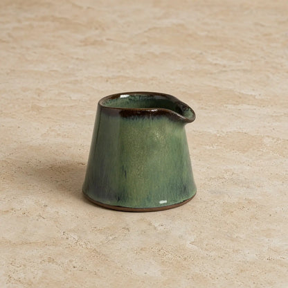 Tiny handmade ceramic pitcher with glossy green glaze and dark brown rim perfect as a ceramic condiment pitcher