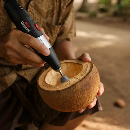 Black and silver dremel tool carving hand-carved coconut shades from brown coconut shells for tropical patio string lights
