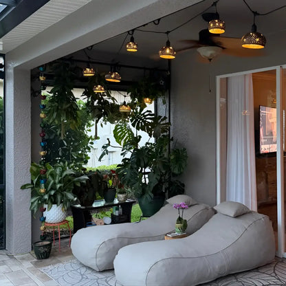 Gray fabric bean bag chair with matching pillows paired with hand carved coconut shades for tropical patio vibes