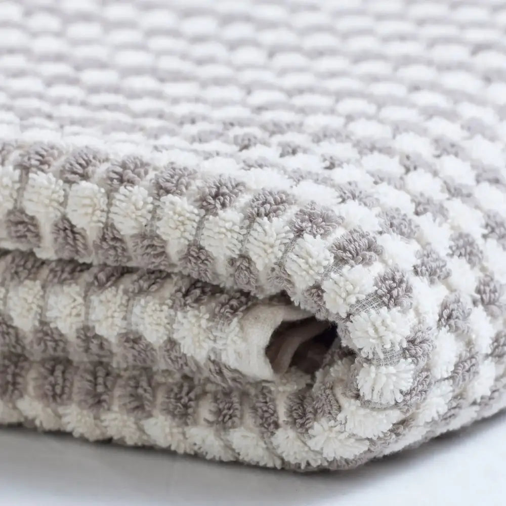 Soft plush blanket with textured checkerboard pattern, perfect for dotted Turkish hand towels