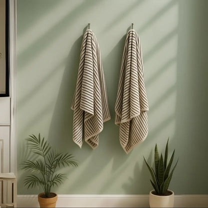 Two Melika Turkish cotton striped towels on pale green wall