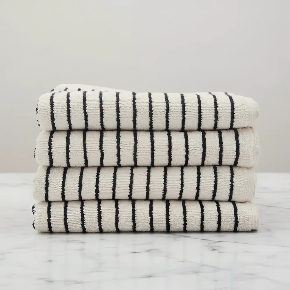 Stack of four Melika Turkish cotton striped towels in cream with bold black stripes