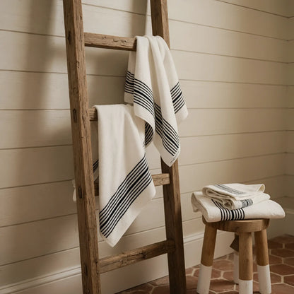 White turkish cotton bath towels with black horizontal stripes hang on a wooden ladder showing striped turkish cotton design