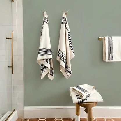 Neatly hung Turkish cotton striped bath towels on green wall