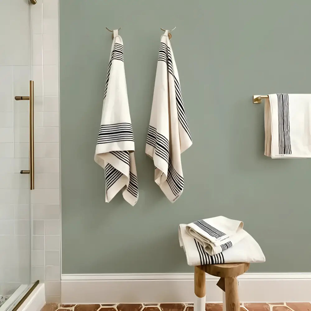 Melika Turkish cotton striped towel hangs neatly on green wall