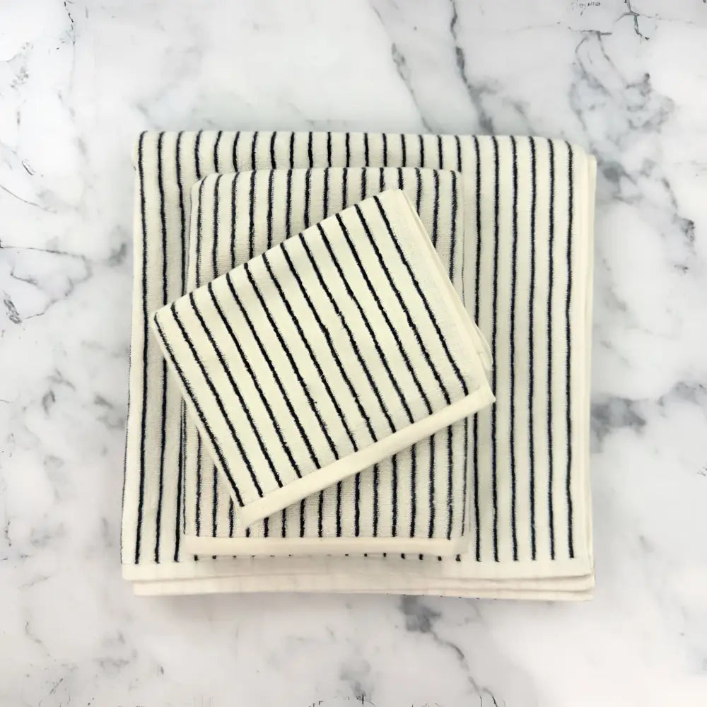 Stacked Turkish cotton striped towels in cream with black stripes