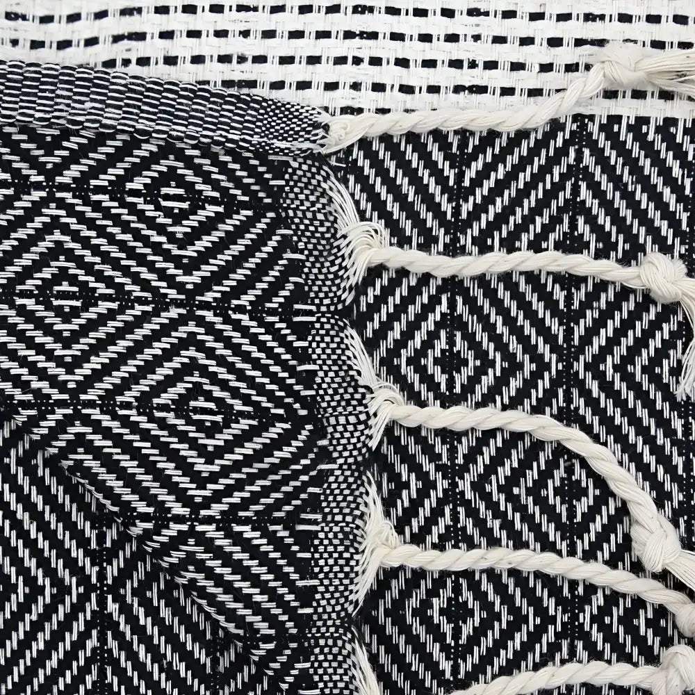 A turkish hand towel with diamonds and dots woven in black.