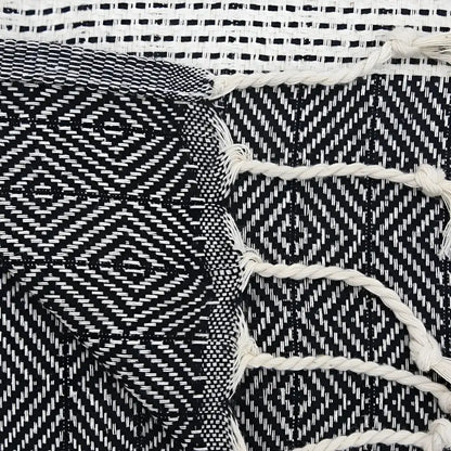 A turkish hand towel with diamonds and dots woven in black.