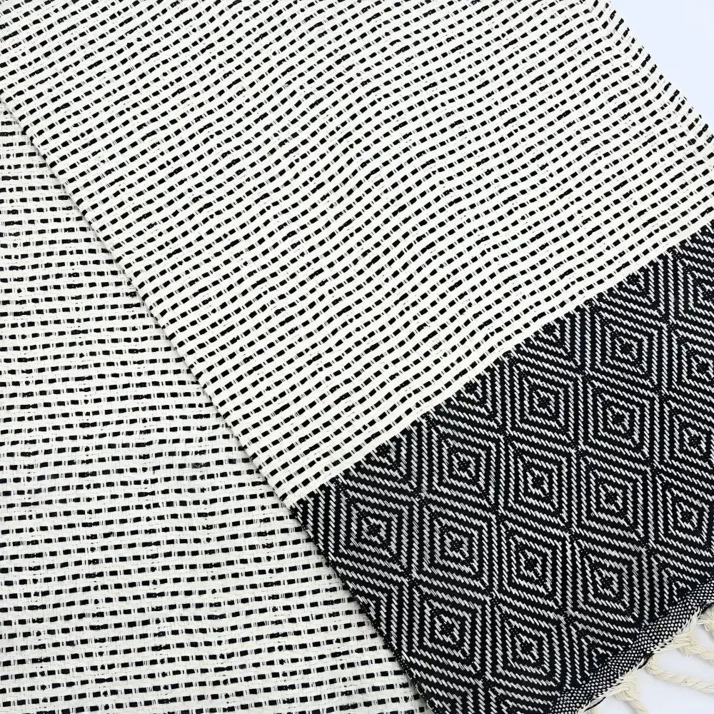A turkish hand towel with diamonds and dots woven in black.