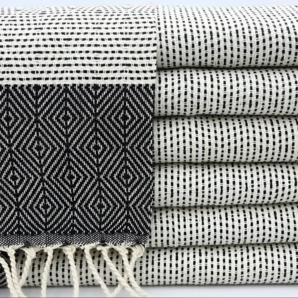 A turkish hand towel with diamonds and dots woven in black.