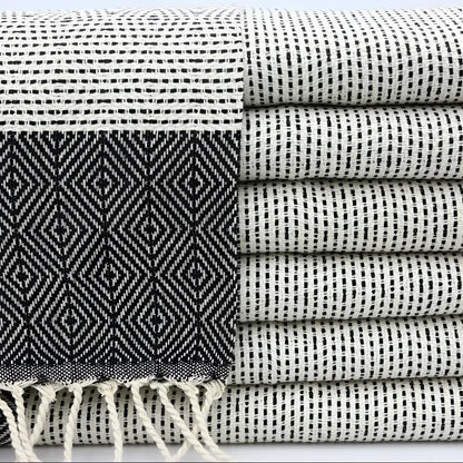 A turkish hand towel with diamonds and dots woven in black.