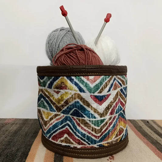 Soft basket created from Turkish rug remnants in colorful geometric design.