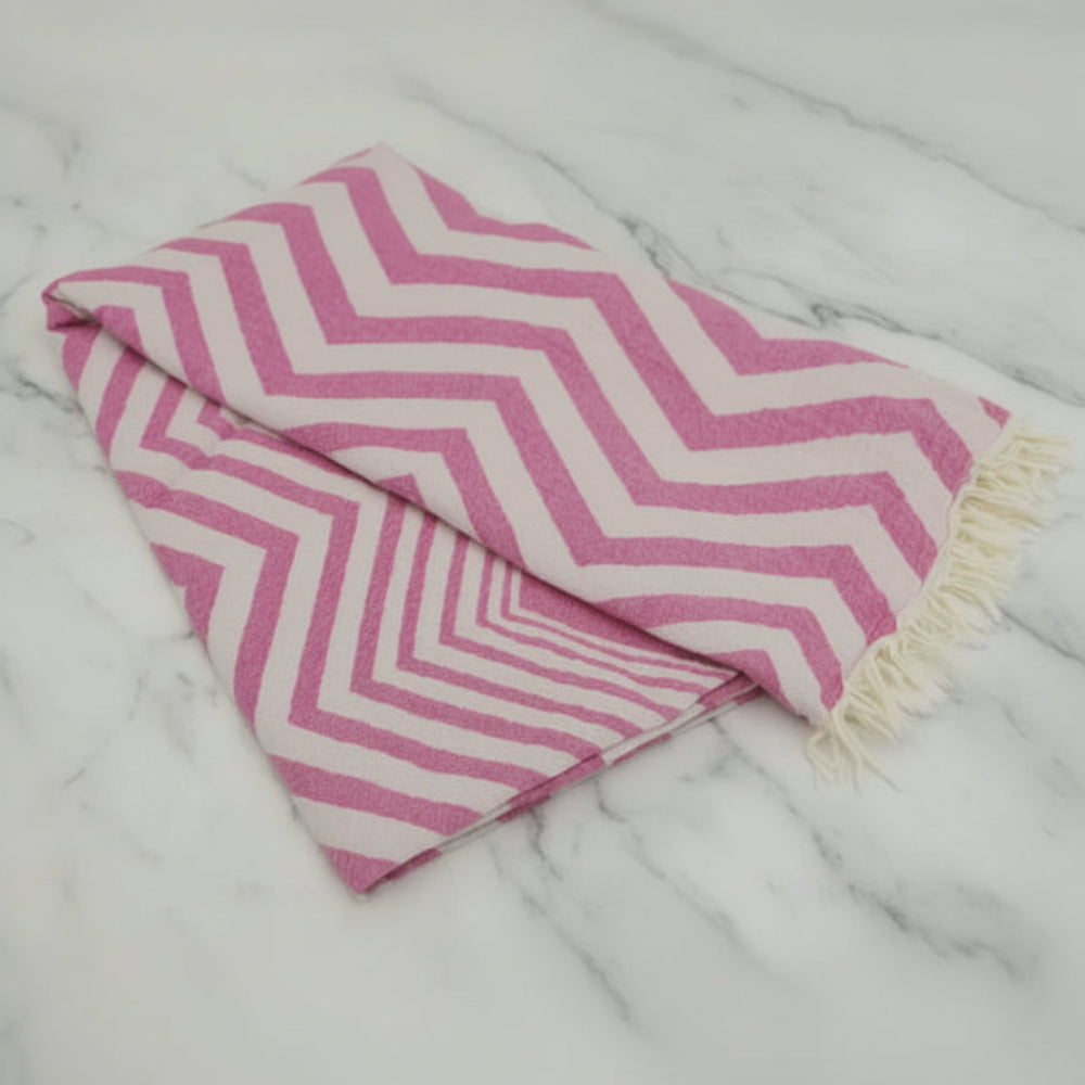 Pink and white chevron pattern peshtemal towel with fringed edges perfect as a lightweight turkish towel