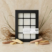 Black-framed box of twelve white square vetiver santal soy wax melts with smoky vetiver and woody sandalwood accord
