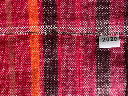 A handmade climate warming ethiopian table runner with bold red orange and dark brown woven vertical stripes