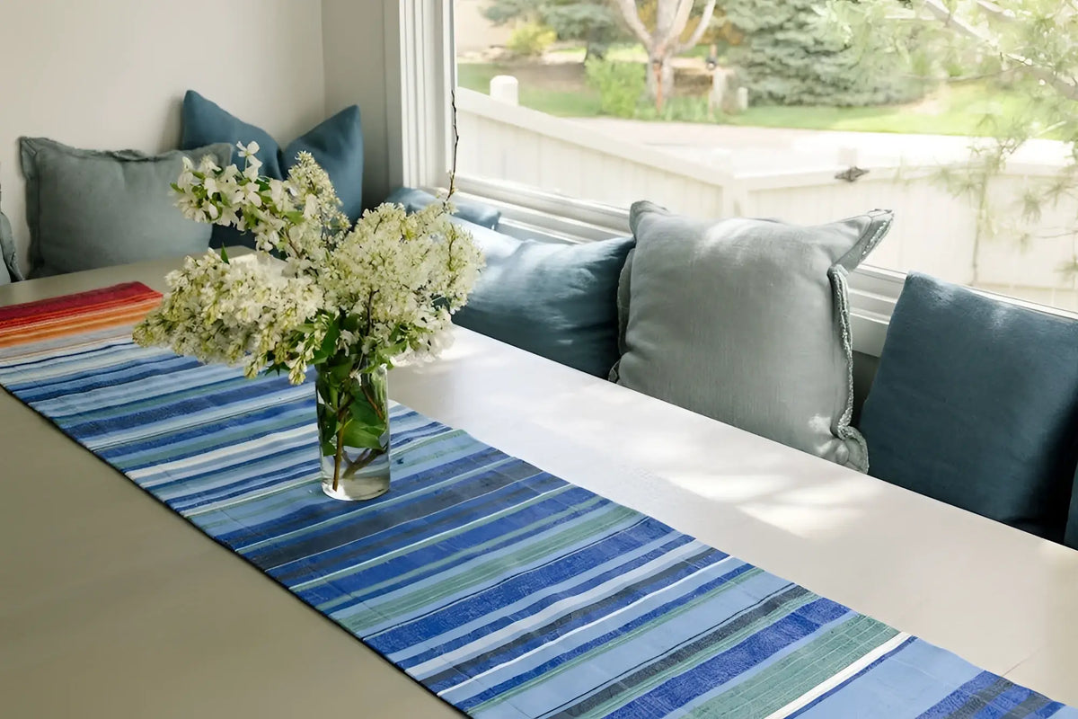 A handmade climate warming ethiopian handwoven table runner in blue, red, orange, and green 