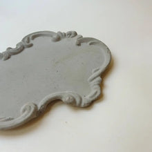 Gray concrete tray with Victorian scroll edging.