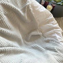 Sand colored waffle textured soft throw blanket.