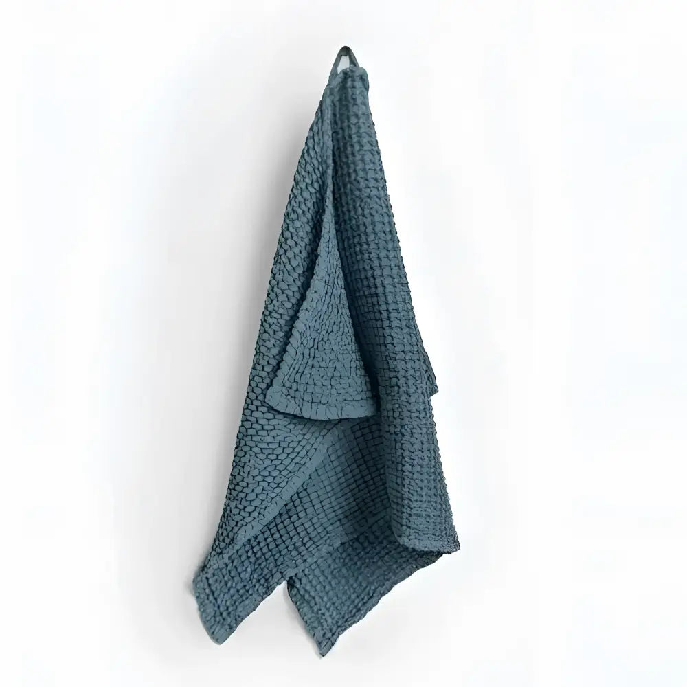Teal linen-cotton blend waffle kitchen towel hanging from hook, specialized waffle weave