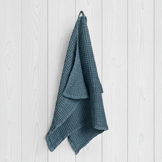 Teal linen-cotton blend waffle kitchen towel hanging from hook, specialized waffle weave