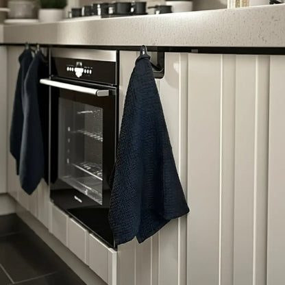 Modern black built-in oven with linen-cotton blend waffle kitchen towel hanging nearby