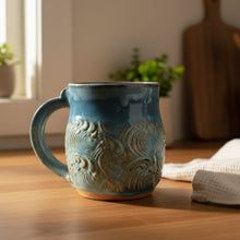 Turquoise handmade pottery mug with wave design perfect for coffee or tea lovers