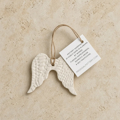 White ceramic angel wing ornament with textured surface and natural twine loop for year-round gifting