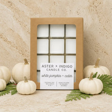 A set of white pumpkin and cedar coconut-soy wax melts in a rustic brown box with toasted hazelnut and rich cocoa scents