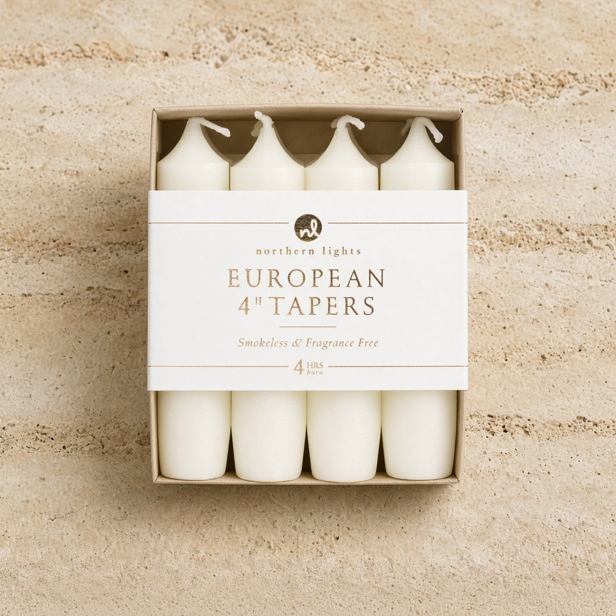 Set of four white unscented taper candles for standard taper holders in a minimalist box measuring 4 inch