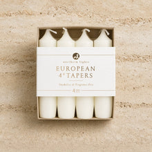 Set of four white unscented taper candles for standard taper holders in a minimalist box measuring 4 inch