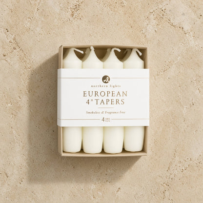 White unscented taper candles in a minimalist box labeled smokeless for standard taper holders 4 inch use
