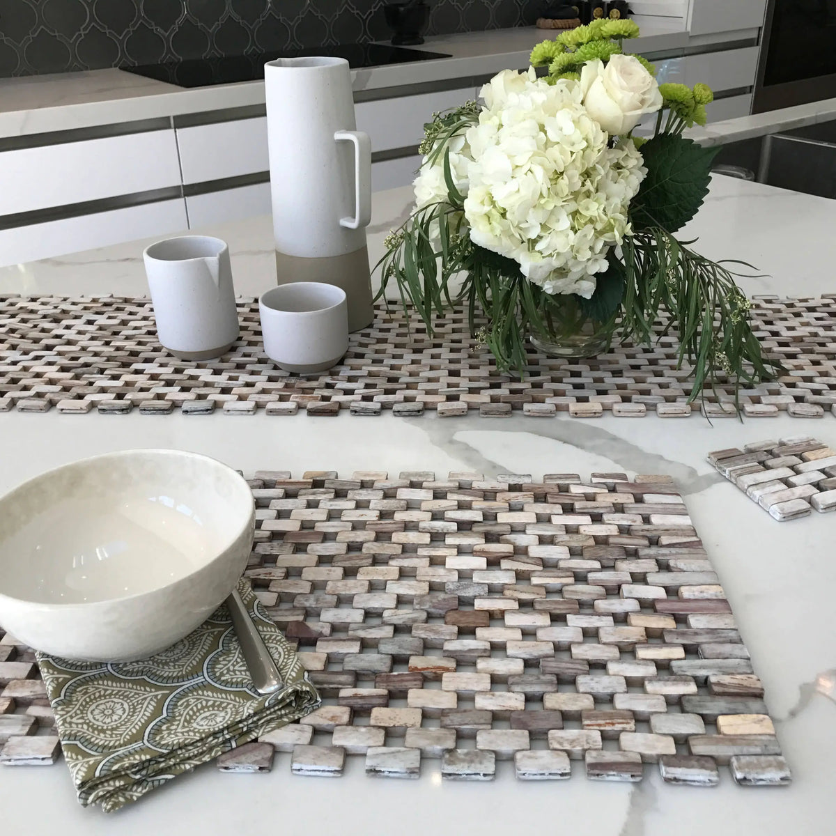 Decorative table runner and placemats made of small, light-colored tiles from the Whitewashed Rosewood Placemat Set
