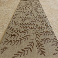 Beige willow table runner with intricate brown embroidered leaf patterns on textured raw silk fabric