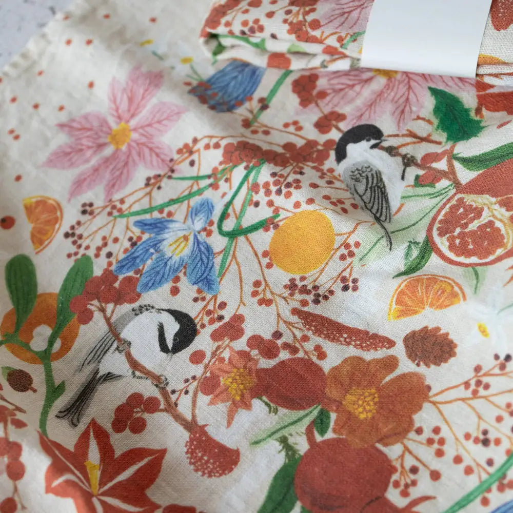 Vibrant floral bird print linen tea towel in oranges, reds, greens on white